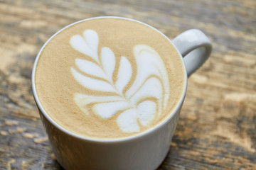 Flower latte foam art. Coffee cup close up.