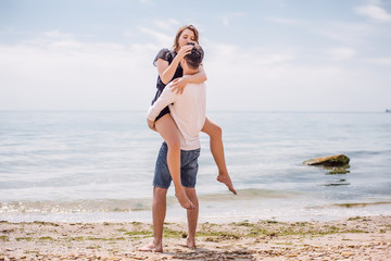 Beautiful Couple At Beach.Outdoor portrait happy beautiful couple,couple having fun by sea,enjoy vacation,trendy hipster look,happiness,love,summer holidays,man touching girlfriend,tan