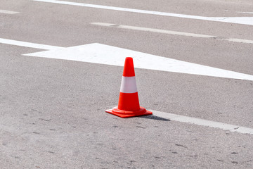 Work on the road. Street signs and road marking. Traffic signs for signaling. Road maintenance, under construction sign and traffic cones on road. Road block with white arrow showing alternate way.
