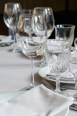 Empty glasses for wine on the holiday table. Serving a formal dining event. Cutlery for people in the restaurant.