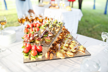 Decorated beautiful table with candles at the celebration. Wedding. Birthday. Romantic dinner in garden. Anniversary. Beautiful glassware. Sunlight.