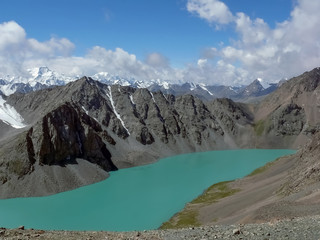 Dramatic Ala kol lake, Tien-Shan, Kyrgyzstan. Sunshine and clouds over the peaks of Terskey Alatau mountain range
