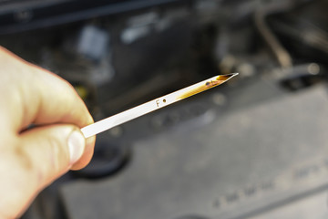 checking the oil level in a car engine
