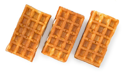 Three fresh soft belgian waffles isolated on white background. Top view, close up.