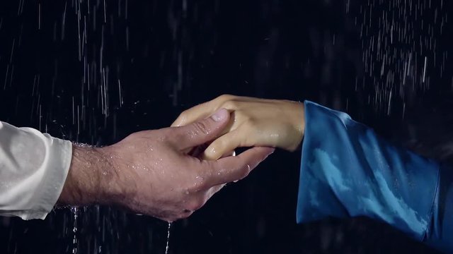 close-up. the breakup between a man and a woman. their hands go to parties in the night time. in bad weather it is raining
