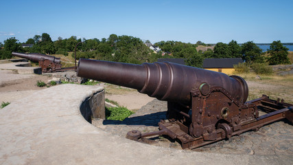 Fototapeta na wymiar Two iron cannons installed on an fortress island next to Helsinki