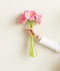 Photo sur Plexiglas Gerbera Bras de femme avec tatouage de poignet d& 39 amour tenant des gerberas roses - amour, concept de cadeau