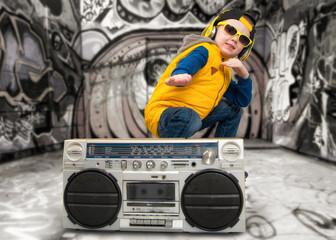 The boy listened to vintage tape recorder.Vintage style .Children's fashion.Graffiti on the walls.	