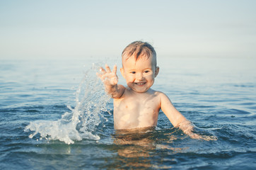 Fototapeta na wymiar Happy baby playing in the sea