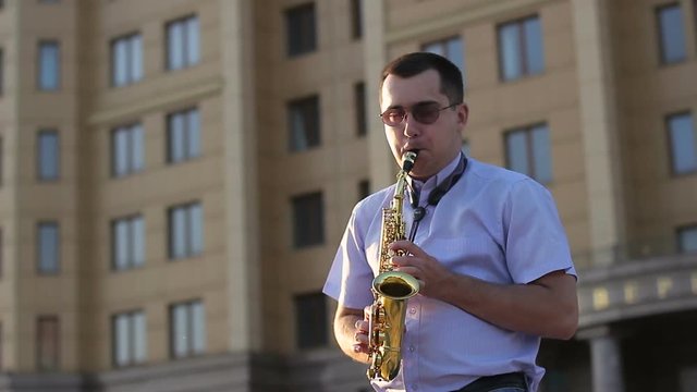 Young musician playing the saxophone on the street