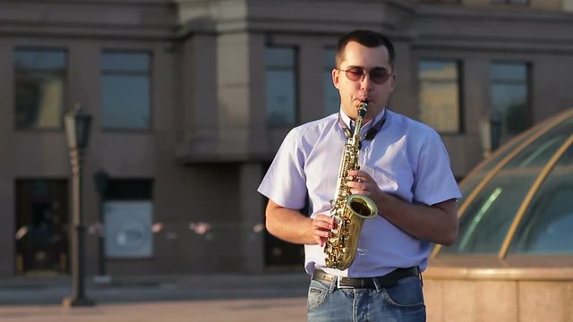 A man performing jazz compositions on a saxophone in the street