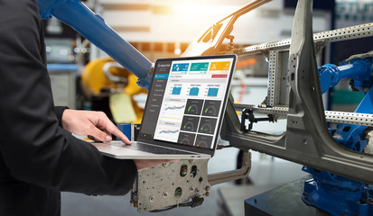 Male manager hand laptop for check real time production monitoring system application in smart factory industrial. Automated conveyor systems for package transfer machine Industry 4.0 and iot concept. - obrazy, fototapety, plakaty