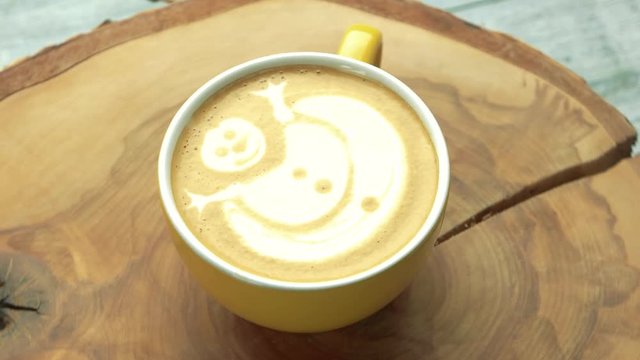 Coffee cup with snowman art. Latte on wooden surface.