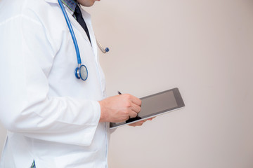 Doctor working on a digital tablet on white background.