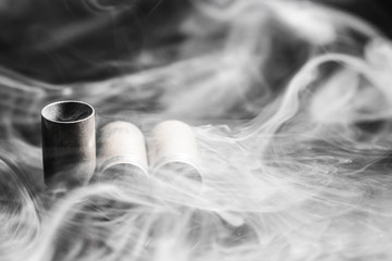 Three empty shell casings from pistol cartridges in a thick clear smoke