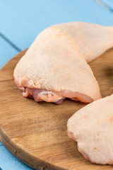 Raw chicken drumsticks on the kitchen wooden board