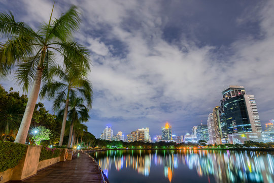 Skyscraper business district of bangkok city view with water reflection of skyline, taken from Benjakitti park on Ratchadapisek Road in Bangkok, Thailand
