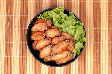 Deep fried chicken wings topped green oak.