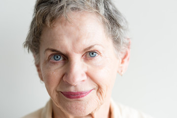 Close up portrait of beautiful older woman with short grey hair and blue eyes (selective focus)