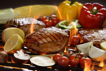 Grilled meat /steak with vegetable on the flaming grill