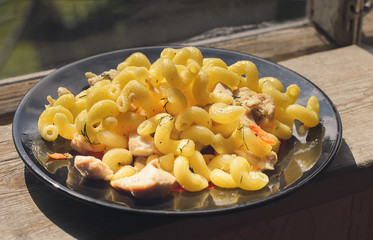 Pasta with fried chicken and carrots close-up