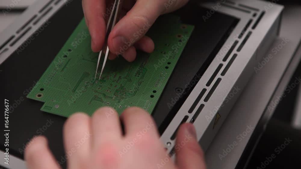 Poster hand with tool repairing cell phone and other gadgets. microchip production factory. technological p