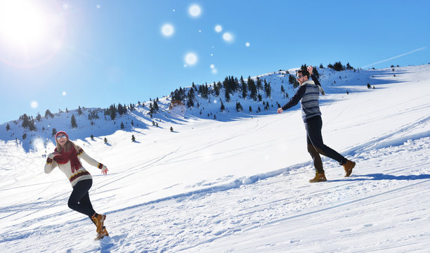 Cheerful young couple having fun in winter park