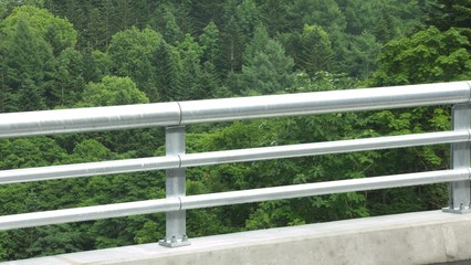 Fototapeta na wymiar 真新しい銀色の欄干　森に架かる橋