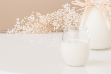 A glass of milk and a pitcher of milk on marble table.