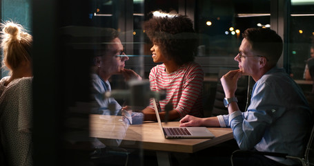Multiethnic startup business team in night office