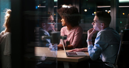 Multiethnic startup business team in night office