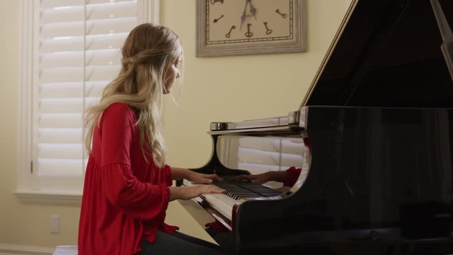 Medium panning shot of woman playing piano / Cedar Hills, Utah, United States