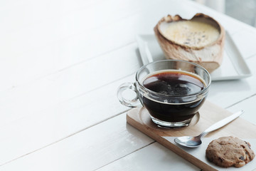 The Coconut Creme Brulee is sugary flavours and drink with hot americano black coffee on white wooden table background 