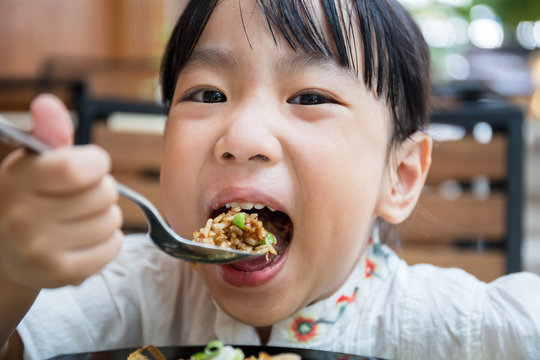 Asian Chinese little girl eating fried rice