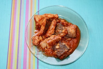 Fish, a dish of fish, seafood, food, canned food, canned fish, fish in tomato, blue napkin, fish in a plate,