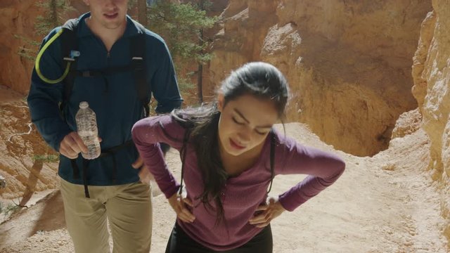 Medium slow motion shot of hikers resting and woman drinking water / Bryce Canyon National Park, Utah, United States