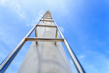 High steel ladder on clear blue sky background