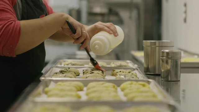 Close up shot of baker brushing cookies with icing / Salt Lake City, Utah, United States