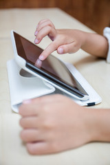 Fototapeta premium Child's hands playing tablet computer