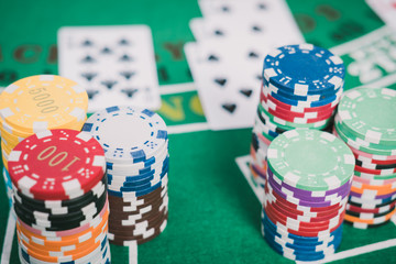Gambling chips and cards on a green cloth Casino table