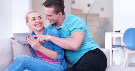 couple relaxing at  home with tablet computers