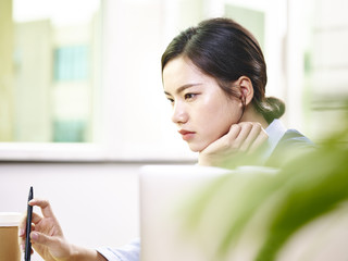 contemplating asian businesswoman working in office