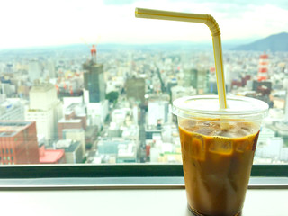 Iced coffee cup and the Top view of T38 Observatory desk at JR tower Sapporo, Japan