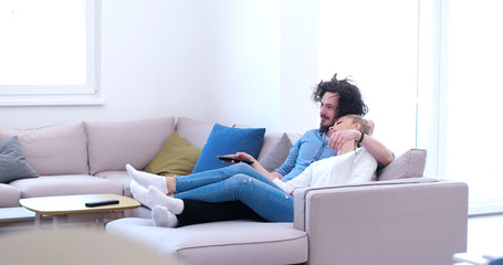 Young couple on the sofa watching television