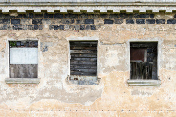 boarded up windows of abandoned house. old decay building facade.