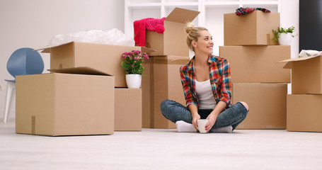 woman with many cardboard boxes sitting on floor
