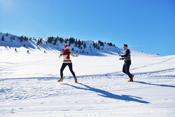 Cheerful young couple having fun in winter park