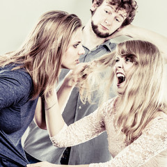 Aggressive mad women fighting over man.