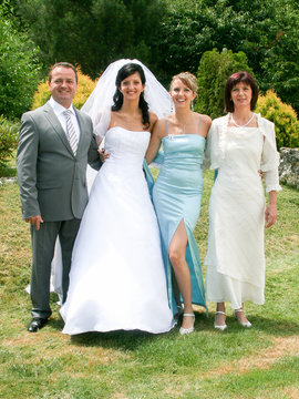 Family Group At Wedding bride with parents and sister. Just married. Family photo memory. Wedding dresses.