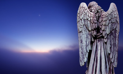 Angel sculpture over dark sky panoramic view